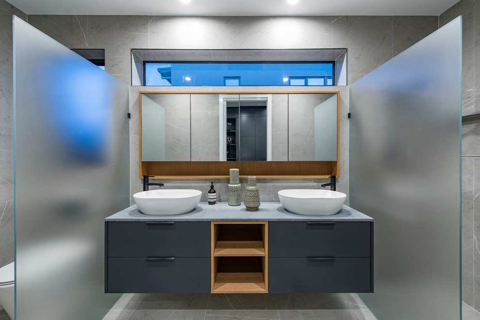 Design ideas for a contemporary bathroom in Canberra - Queanbeyan with flat-panel cabinets, grey cabinets, an alcove shower, gray tile, a vessel sink, grey floor and grey benchtops.