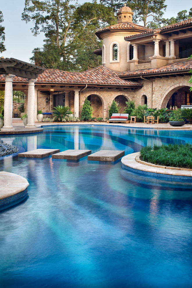 This is an example of an expansive mediterranean backyard custom-shaped pool in Houston.