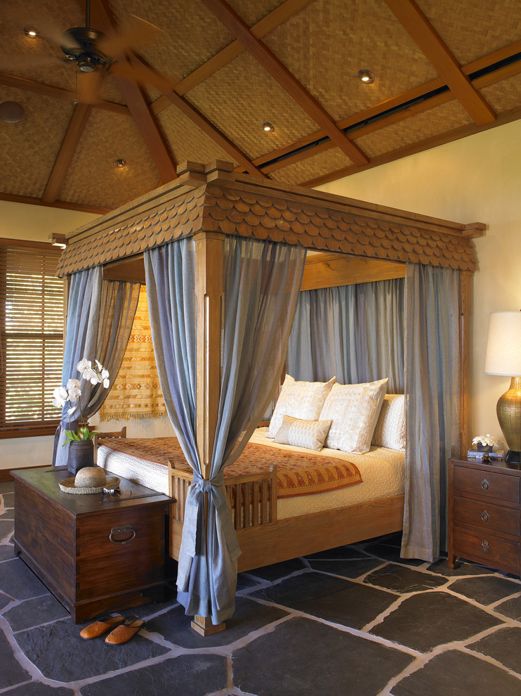 Photo of a tropical bedroom in Hawaii with white walls and slate floors.