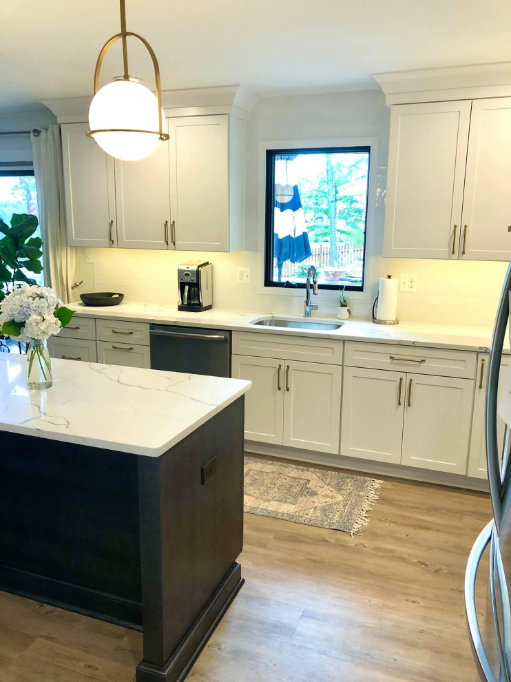 Bild på ett mellanstort lantligt vit vitt kök och matrum, med en undermonterad diskho, skåp i shakerstil, vita skåp, bänkskiva i kvartsit, vitt stänkskydd, stänkskydd i tunnelbanekakel och en köksö