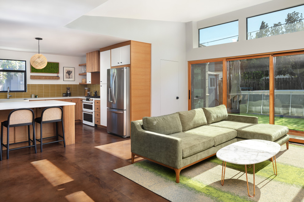 На фото: открытая гостиная комната среднего размера в стиле ретро с серыми стенами, бетонным полом, отдельно стоящим телевизором, коричневым полом и сводчатым потолком
