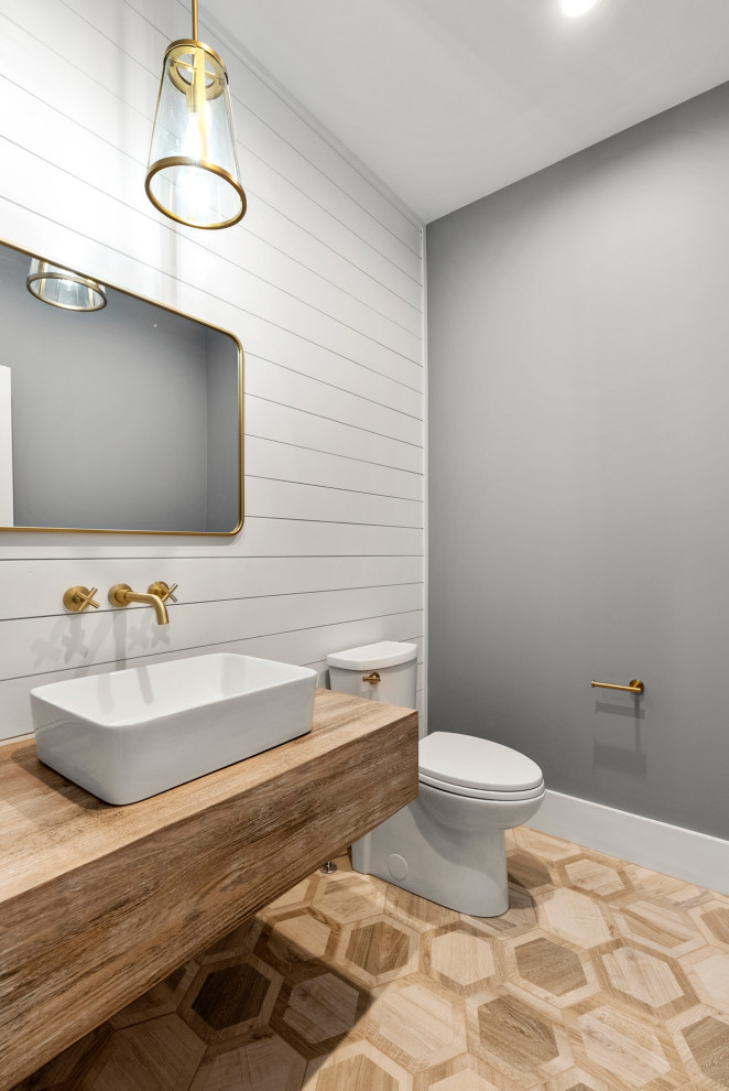 Inspiration for a mid-sized country 3/4 bathroom in Boston with open cabinets, medium wood cabinets, a one-piece toilet, grey walls, medium hardwood floors, a console sink, wood benchtops, brown floor, brown benchtops, a single vanity and a floating vanity.