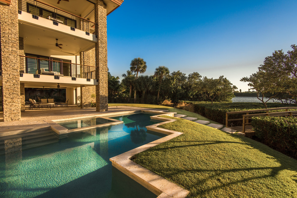 Inspiration for a large rustic backyard stone and custom-shaped natural hot tub remodel in Tampa