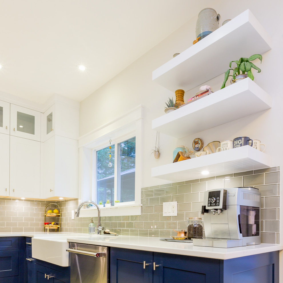 Example of a large transitional u-shaped light wood floor open concept kitchen design with a farmhouse sink, shaker cabinets, blue cabinets, quartz countertops, gray backsplash, glass tile backsplash, stainless steel appliances, an island and white countertops