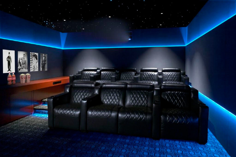 Large eclectic enclosed home theatre in New York with black walls, carpet, a projector screen and blue floor.
