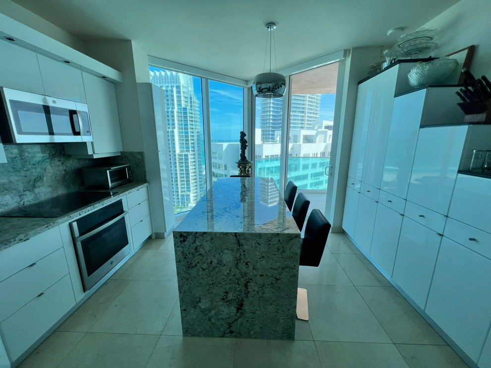 Zweizeilige, Mittelgroße Moderne Wohnküche mit weißen Schränken, Granit-Arbeitsplatte, Rückwand aus Granit und Kücheninsel in Miami