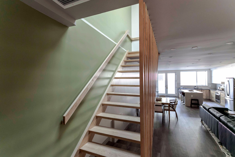 This is an example of a mid-sized modern wood straight staircase in New York with open risers and wood railing.