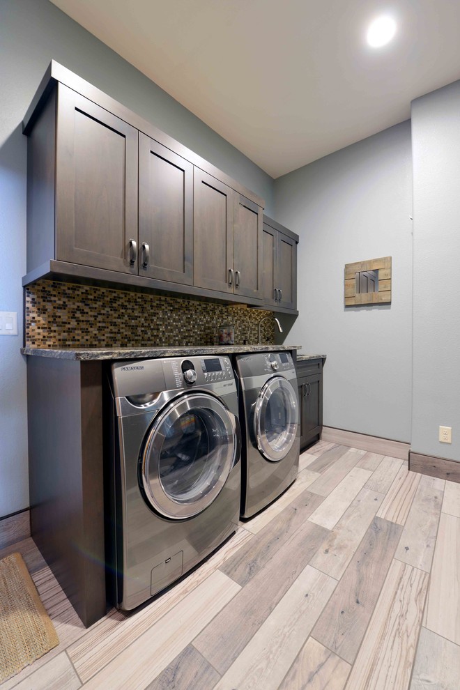 Design ideas for a large country utility room in Other with shaker cabinets, dark wood cabinets, granite benchtops, grey walls, laminate floors and a side-by-side washer and dryer.