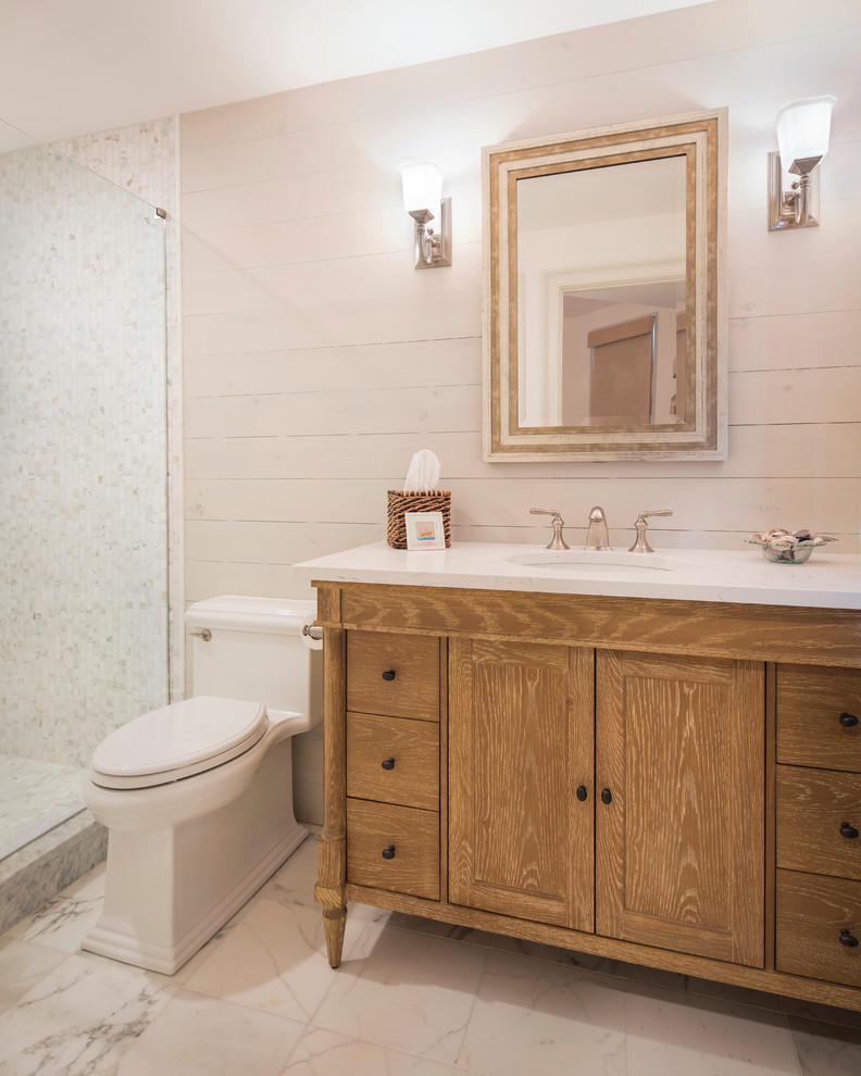 Photo of a mid-sized transitional bathroom in New York with recessed-panel cabinets, white cabinets, an open shower, white tile, marble, a drop-in sink, marble benchtops and a hinged shower door.