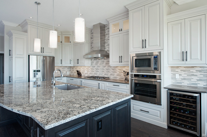 Example of a large transitional l-shaped dark wood floor open concept kitchen design in Calgary with an undermount sink, raised-panel cabinets, white cabinets, granite countertops, multicolored backsplash, matchstick tile backsplash, stainless steel appliances and an island