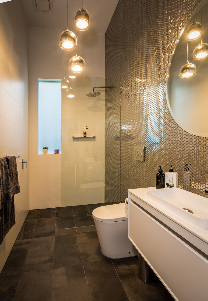 Photo of a mid-sized modern kids bathroom in Melbourne with flat-panel cabinets, white cabinets, an open shower, a one-piece toilet, gray tile, pebble tile, white walls, ceramic floors, a console sink, engineered quartz benchtops, grey floor, white benchtops, a single vanity and a floating vanity.