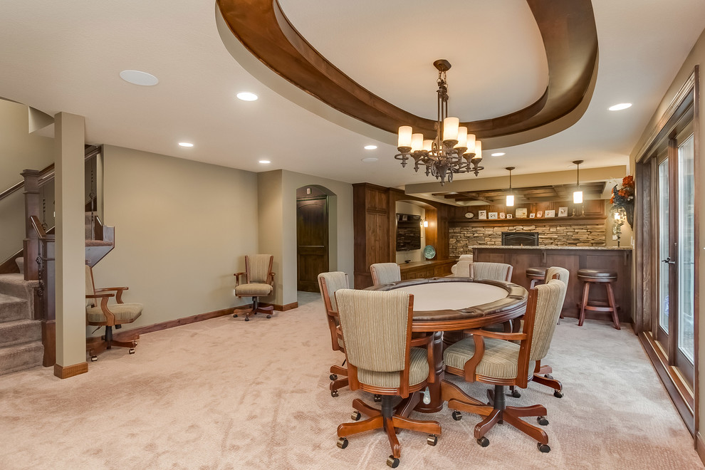 This is an example of a mid-sized traditional look-out basement in Minneapolis with beige walls, carpet, a standard fireplace, a stone fireplace surround and beige floor.