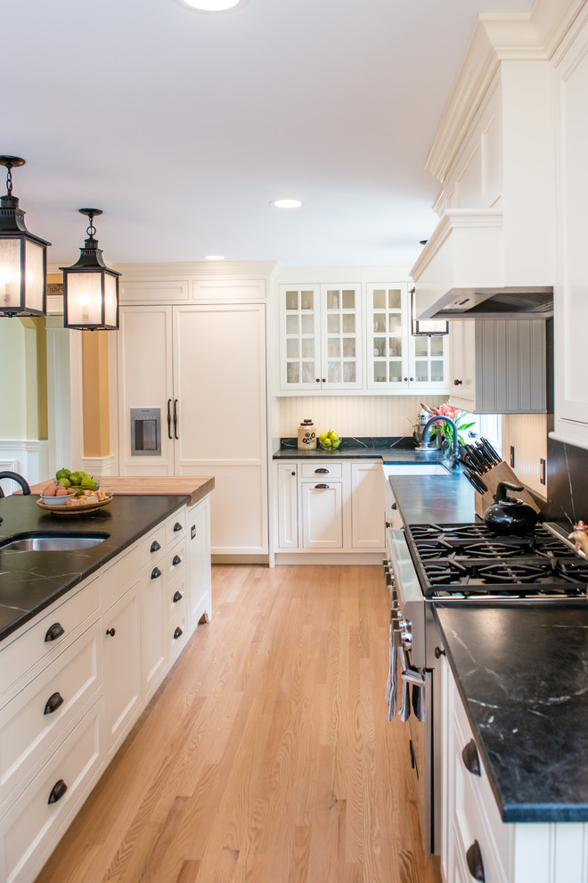 Design ideas for a mid-sized transitional u-shaped eat-in kitchen in Portland Maine with an undermount sink, shaker cabinets, white cabinets, stainless steel appliances, bamboo floors and with island.