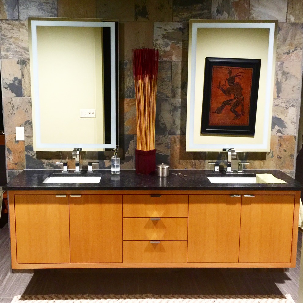 Mid-sized modern master bathroom in Little Rock with an undermount sink, flat-panel cabinets, medium wood cabinets, soapstone benchtops, a drop-in tub, a double shower, a two-piece toilet, gray tile, stone tile, yellow walls and porcelain floors.