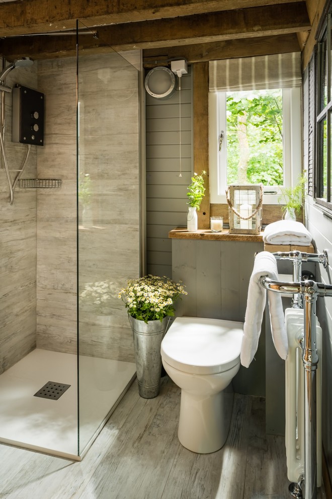 Inspiration for a small country master bathroom in Sussex with a corner shower, a one-piece toilet, gray tile, ceramic tile, grey walls, light hardwood floors, wood benchtops, grey floor and an open shower.