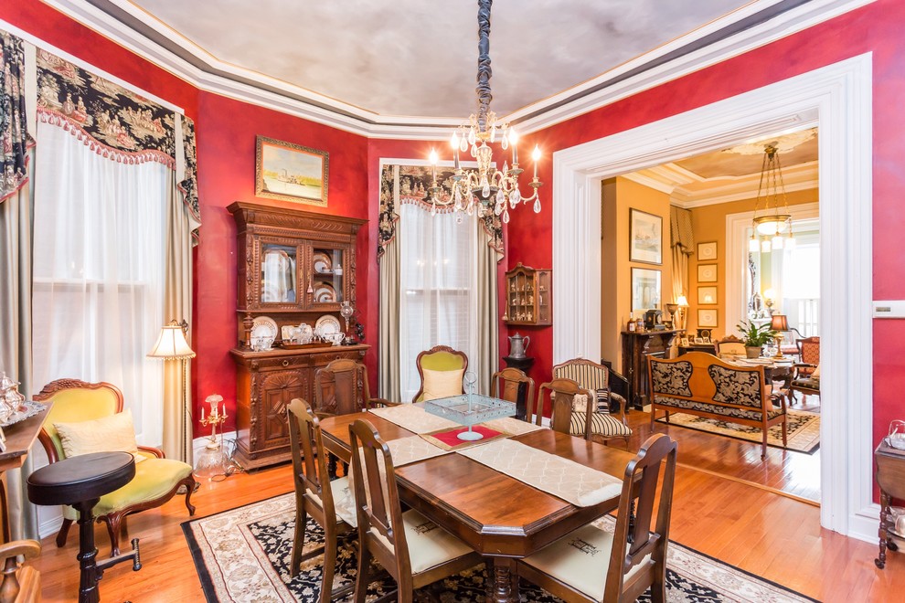 Photo of a mid-sized traditional separate dining room in St Louis with red walls, light hardwood floors and no fireplace.