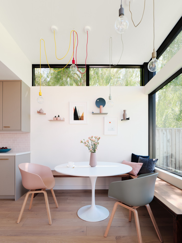 Diseño de comedor minimalista con paredes blancas, suelo de madera clara y suelo beige