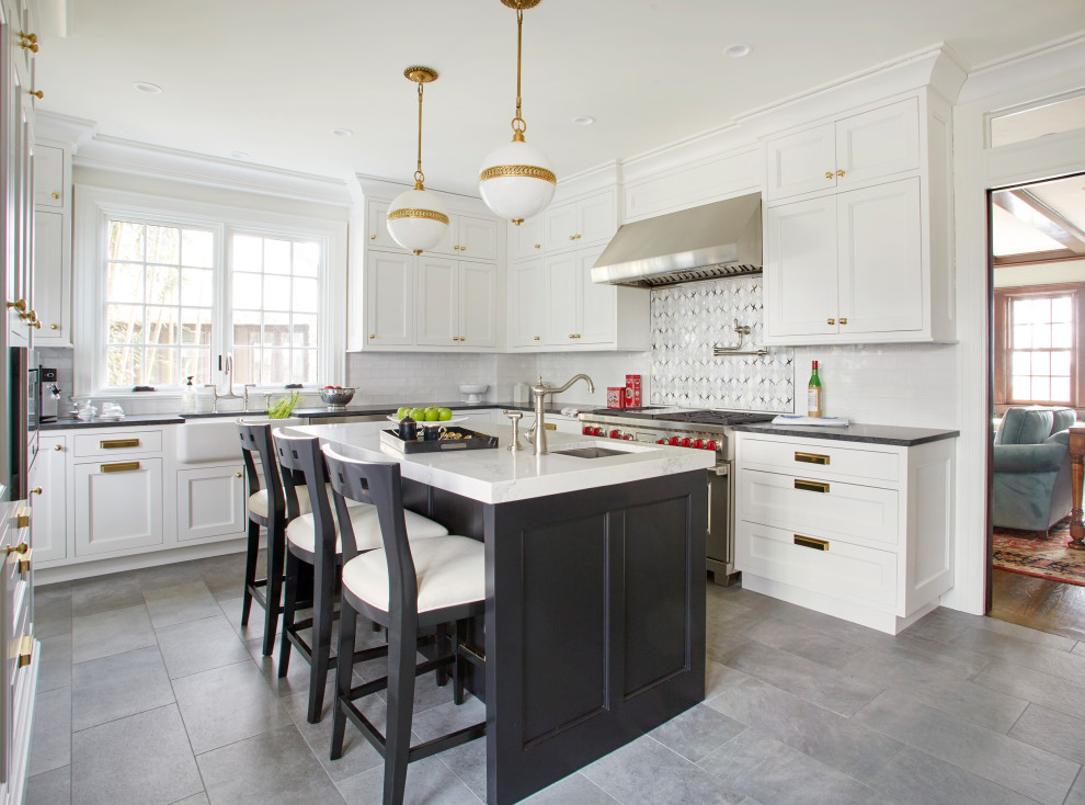 Klassisk inredning av ett mellanstort vit vitt kök, med en rustik diskho, luckor med infälld panel, svarta skåp, granitbänkskiva, flerfärgad stänkskydd, stänkskydd i mosaik, integrerade vitvaror, mellanmörkt trägolv, en köksö och brunt golv