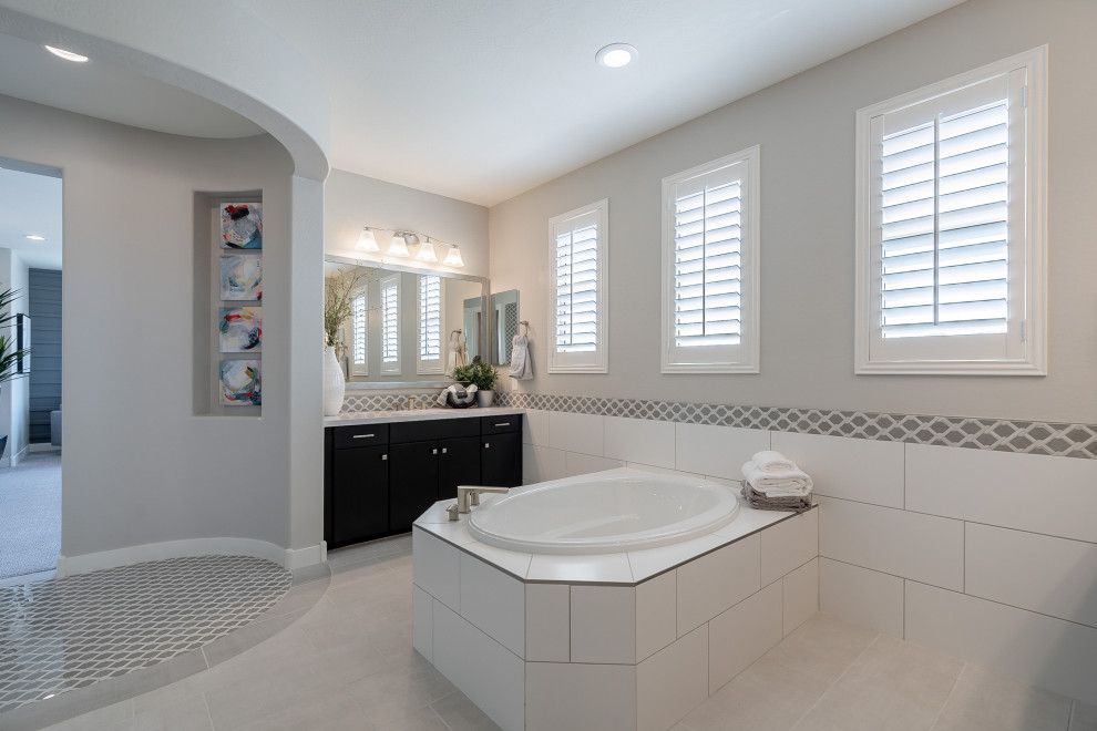 Design ideas for a mid-sized contemporary master bathroom in Phoenix with flat-panel cabinets, black cabinets, an alcove shower, beige tile, ceramic tile, beige walls, light hardwood floors, an undermount sink, solid surface benchtops, beige floor, white benchtops and an open shower.