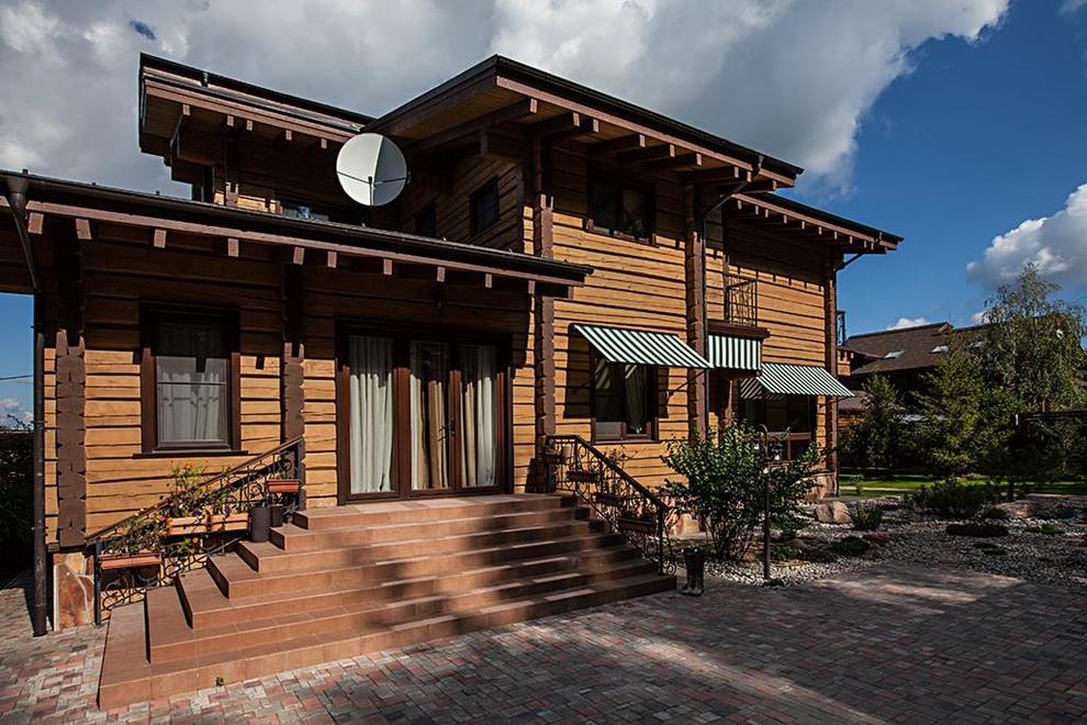 Inspiration for a large country three-storey beige exterior in Moscow with wood siding and a gable roof.