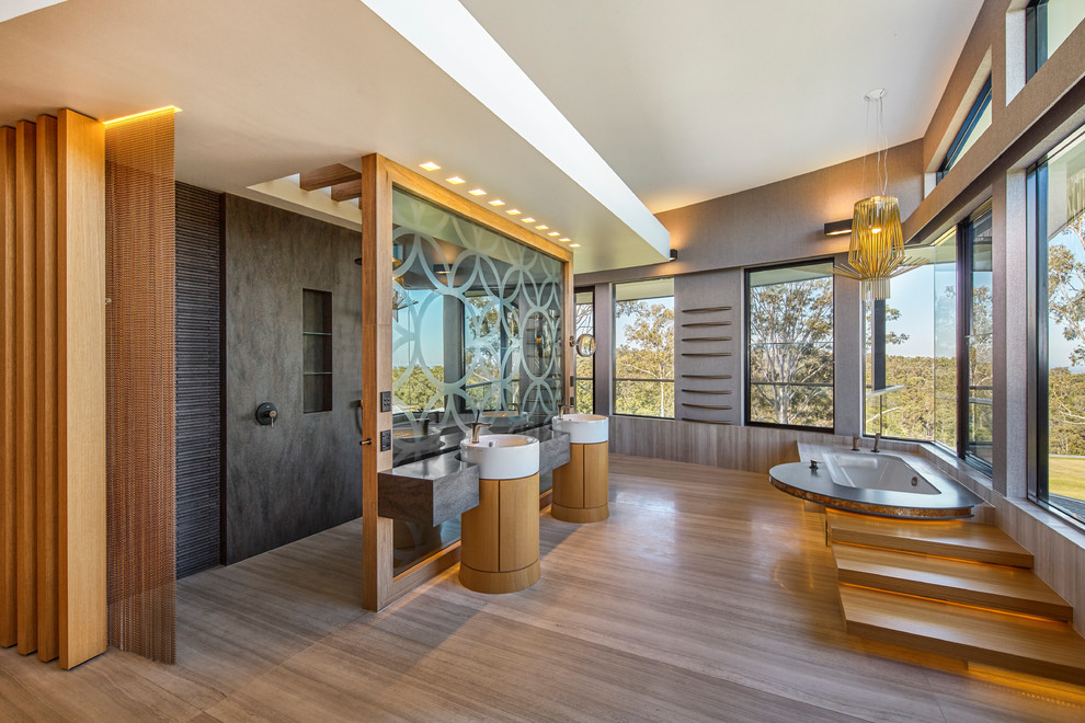 Design ideas for a large contemporary bathroom in Sydney with medium wood cabinets, an open shower, a vessel sink, solid surface benchtops, flat-panel cabinets, an undermount tub and an open shower.