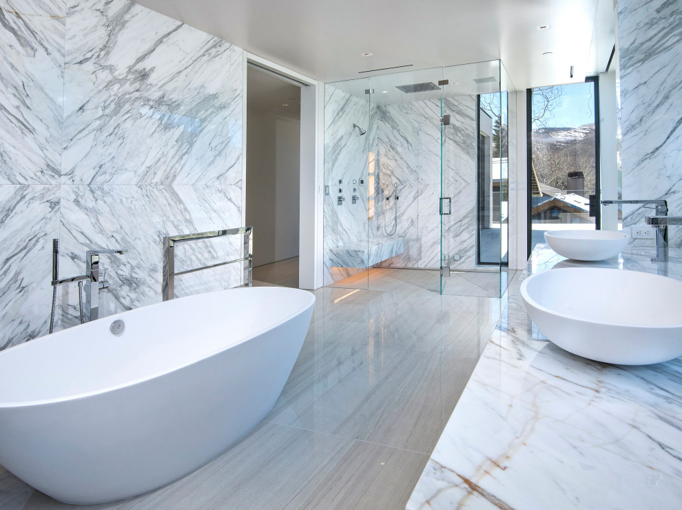 This is an example of a modern bathroom in Denver with marble flooring and marble worktops.
