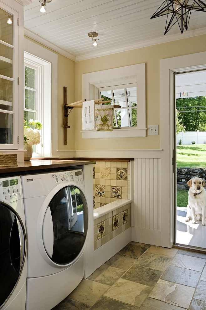 Design ideas for a traditional laundry room in Burlington with a side-by-side washer and dryer, brown benchtop and beige walls.