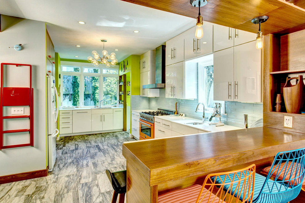 This is an example of a midcentury kitchen in Seattle with white cabinets, subway tile splashback and flat-panel cabinets.