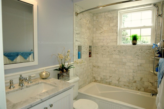 Réalisation d'une salle de bain principale tradition de taille moyenne avec un placard à porte affleurante, des portes de placard blanches, un plan de toilette en marbre, une baignoire posée, un combiné douche/baignoire, un carrelage blanc, un carrelage métro, un mur bleu et un sol en marbre.