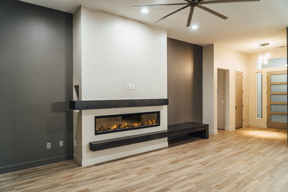 Offenes Modernes Wohnzimmer mit grauer Wandfarbe, Keramikboden, Kamin, Kaminumrandung aus Holz, TV-Wand, braunem Boden, Kassettendecke und Holzwänden in Salt Lake City
