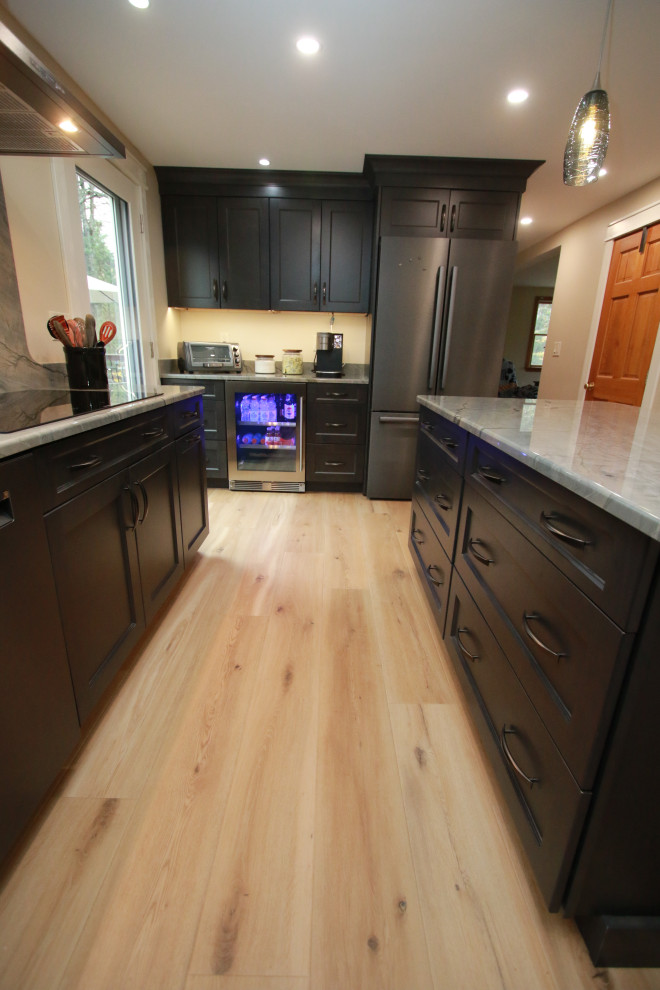 Inspiration for a mid-sized transitional u-shaped laminate floor and brown floor eat-in kitchen remodel in Boston with an undermount sink, shaker cabinets, brown cabinets, quartz countertops, black appliances, an island and multicolored countertops