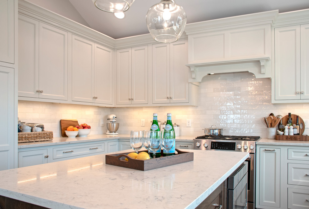 Inspiration for a transitional vaulted ceiling eat-in kitchen remodel with shaker cabinets, white cabinets, quartz countertops, white backsplash, ceramic backsplash, stainless steel appliances, an island and white countertops