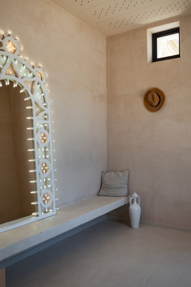 他の地域にある地中海スタイルのおしゃれな玄関ロビー (ベージュの壁、テラゾーの床、金属製ドア、ベージュの床、折り上げ天井、パネル壁) の写真