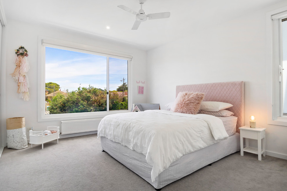 This is an example of a contemporary kids' bedroom for kids 4-10 years old and girls in Melbourne with white walls, carpet and grey floor.