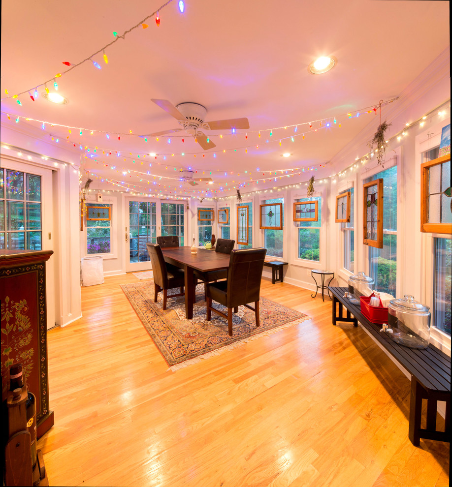 Photo of a large arts and crafts dining room in Baltimore with white walls and light hardwood floors.