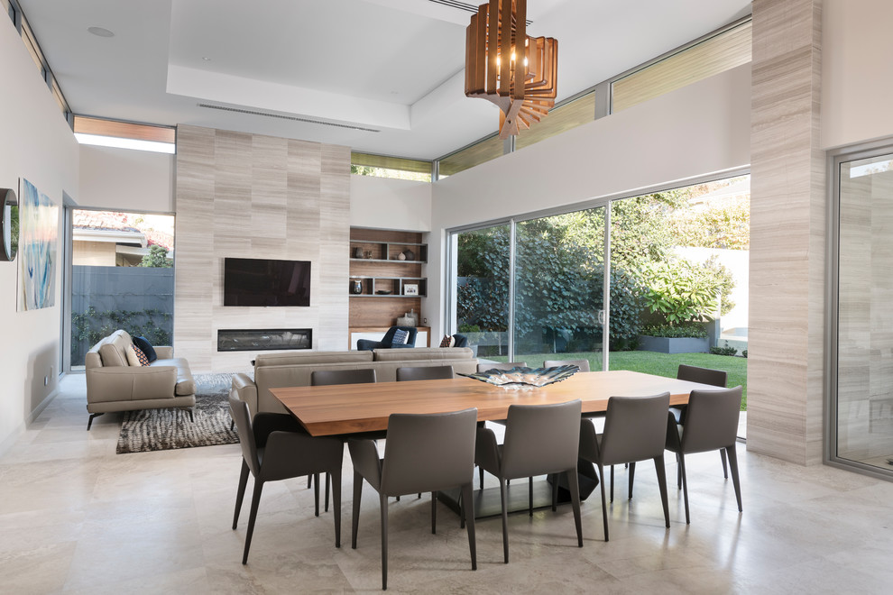 Photo of an expansive contemporary open plan dining in Perth with grey walls, a standard fireplace, a tile fireplace surround, grey floor and limestone floors.