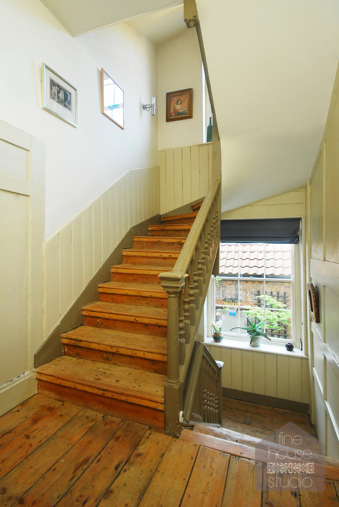 Photo of a large traditional wood u-shaped staircase in London with wood risers.