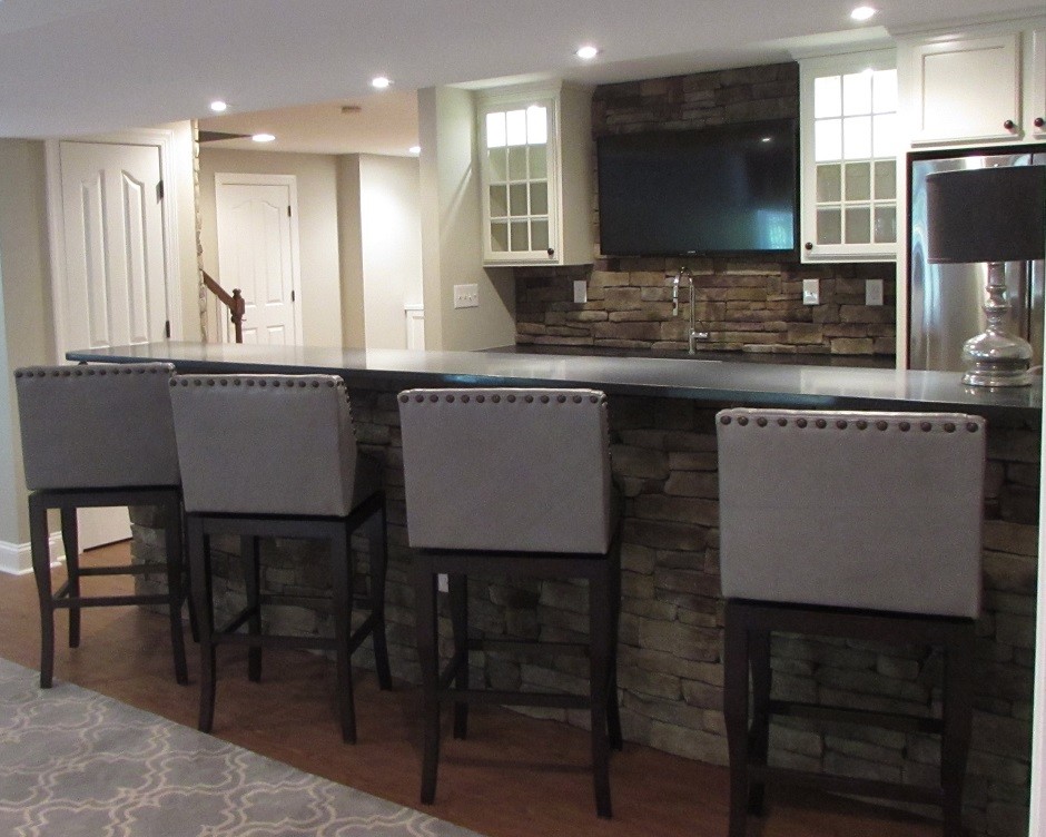 Basement - large walk-out vinyl floor basement idea with beige walls, a standard fireplace and a stone fireplace