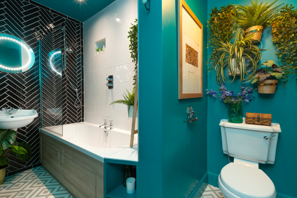 Design ideas for a mid-sized eclectic kids bathroom in Edinburgh with a drop-in tub, a shower/bathtub combo, a one-piece toilet, black and white tile, ceramic tile, green walls, linoleum floors, a wall-mount sink, tile benchtops, grey floor, a hinged shower door and white benchtops.
