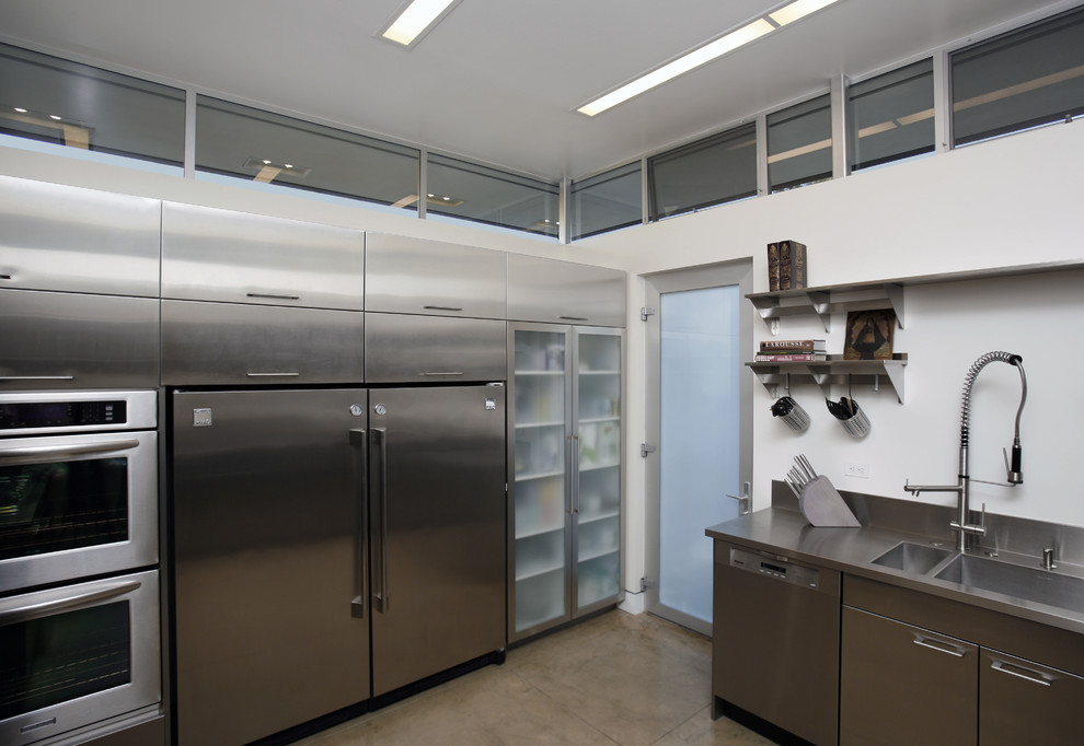 Industrial kitchen in Los Angeles with stainless steel benchtops, an integrated sink and stainless steel cabinets.