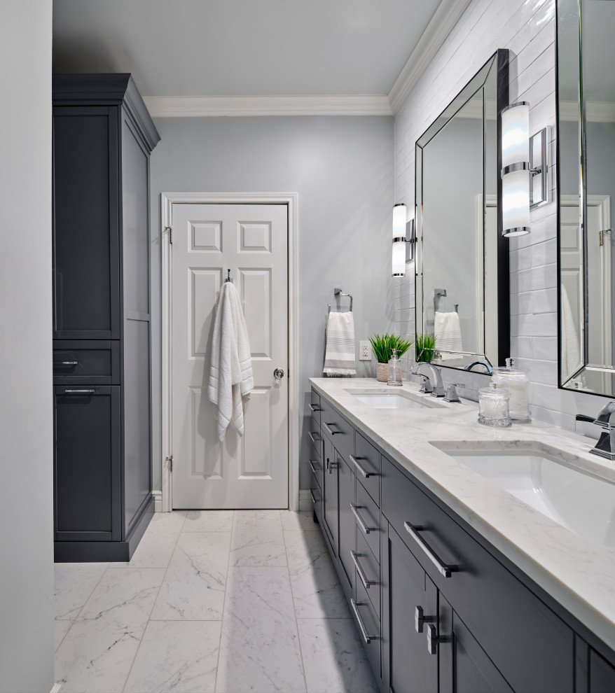 This is an example of a mid-sized transitional bathroom in Austin with grey cabinets, an alcove tub, a shower/bathtub combo, a two-piece toilet, white tile, ceramic tile, grey walls, porcelain floors, an undermount sink, engineered quartz benchtops, grey floor, a shower curtain, white benchtops, a double vanity, a freestanding vanity and shaker cabinets.