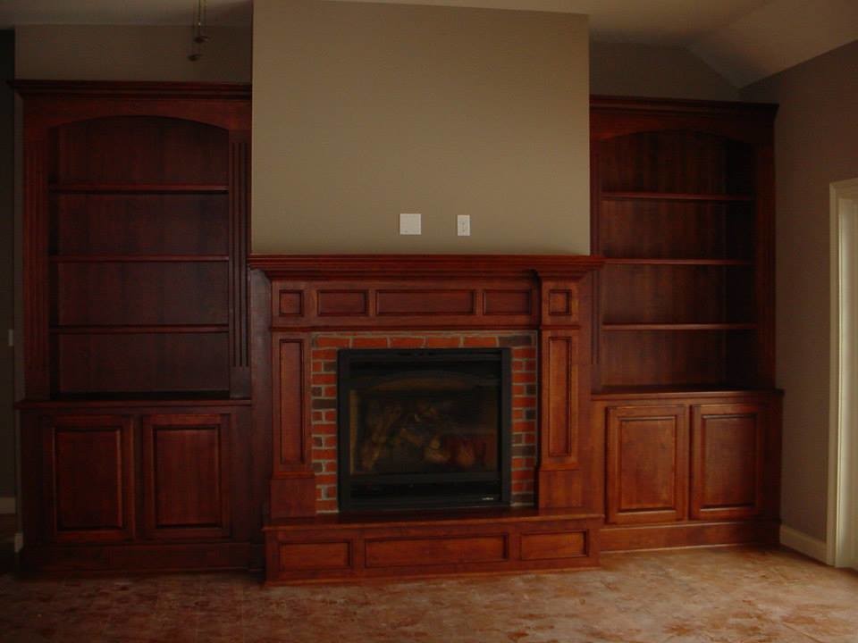 Carpeted living room photo with beige walls, a standard fireplace and a brick fireplace