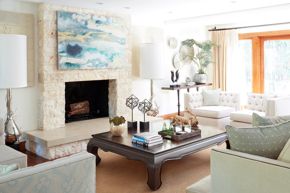 Photo of a mid-sized beach style formal enclosed living room in Los Angeles with white walls, a standard fireplace, a stone fireplace surround, medium hardwood floors, no tv and brown floor.