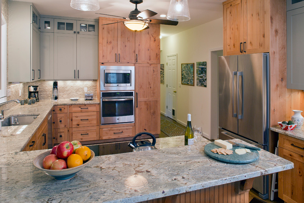 Example of a mid-sized transitional u-shaped medium tone wood floor eat-in kitchen design with shaker cabinets, stainless steel appliances, a peninsula, an undermount sink, medium tone wood cabinets, granite countertops, beige backsplash and matchstick tile backsplash