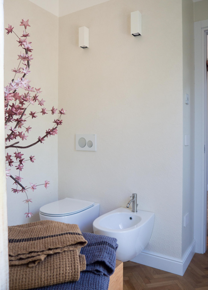 Aménagement d'une salle de bain contemporaine en bois clair de taille moyenne avec un placard à porte plane, WC suspendus, un mur blanc, un sol en bois brun, une vasque, un plan de toilette en bois, aucune cabine, meuble simple vasque et meuble-lavabo suspendu.