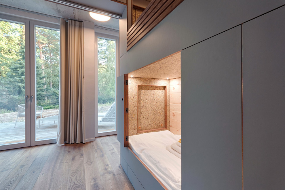 Ispirazione per una camera degli ospiti contemporanea di medie dimensioni con pavimento in legno massello medio