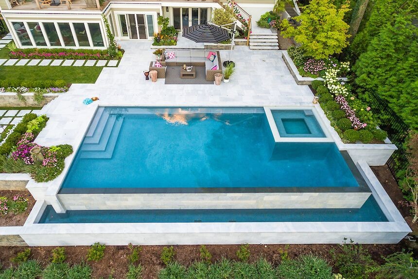 Example of a large backyard stone and custom-shaped hot tub design in New York