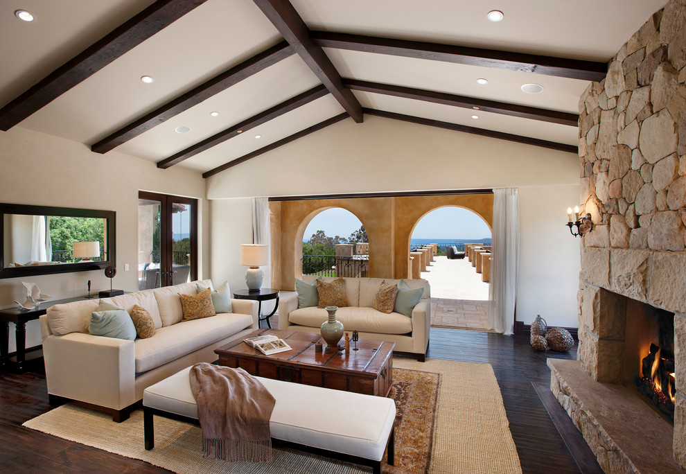 Inspiration for a mediterranean dark wood floor living room remodel in Los Angeles with white walls, a standard fireplace and a stone fireplace