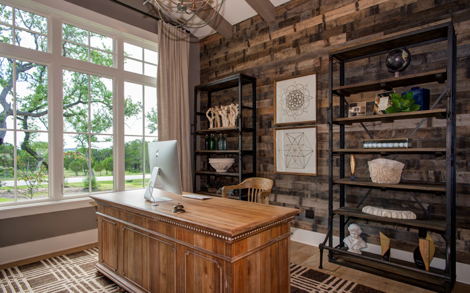 This is an example of a country home office in Other with brown walls, light hardwood floors and a freestanding desk.