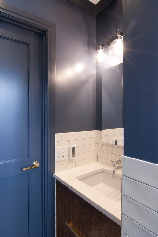 Small transitional bathroom in New York with flat-panel cabinets, medium wood cabinets, an alcove tub, a shower/bathtub combo, a one-piece toilet, white tile, ceramic tile, blue walls, terra-cotta floors, an undermount sink, engineered quartz benchtops, blue floor, a shower curtain and white benchtops.